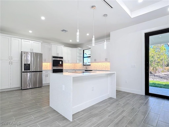 kitchen featuring light countertops, appliances with stainless steel finishes, backsplash, and visible vents