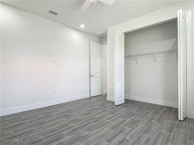 unfurnished bedroom featuring baseboards, visible vents, ceiling fan, wood tiled floor, and a closet