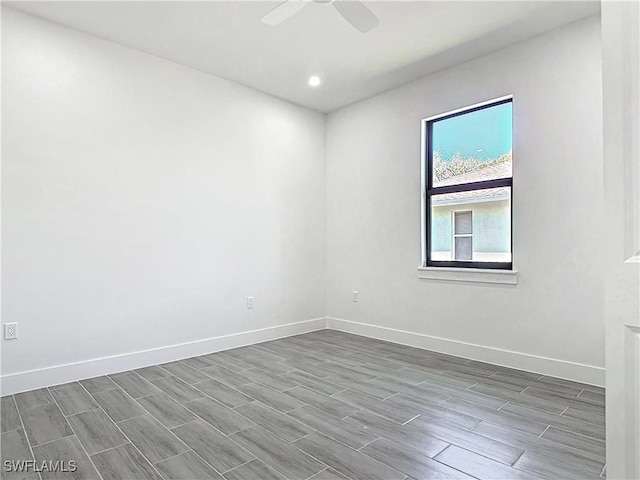 spare room featuring ceiling fan, baseboards, and wood finish floors