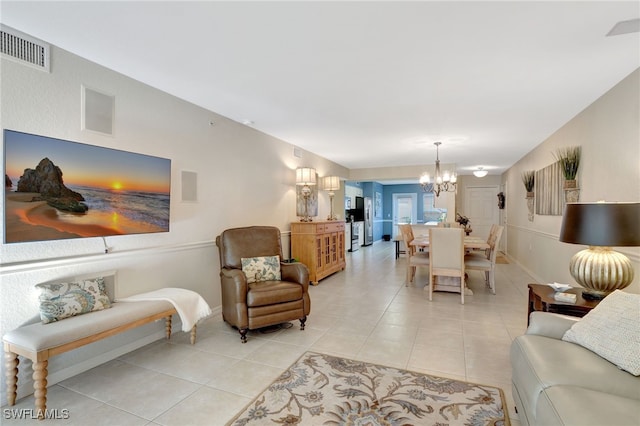 living area with light tile patterned floors, visible vents, a chandelier, and baseboards