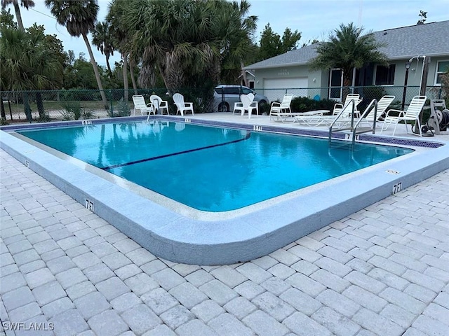 pool with a patio area and fence