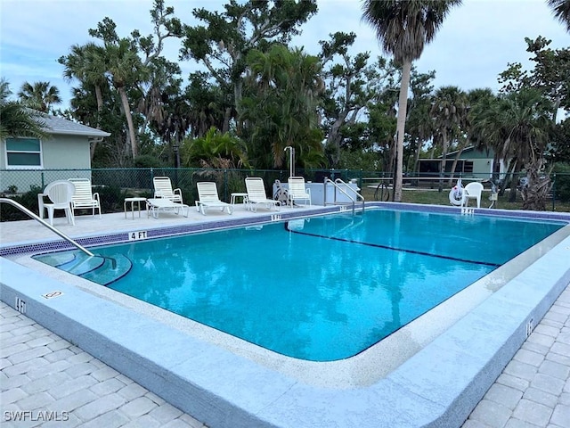 community pool featuring a patio and fence