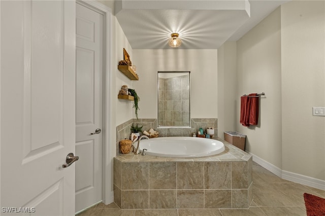 full bathroom with tile patterned floors, baseboards, and a bath