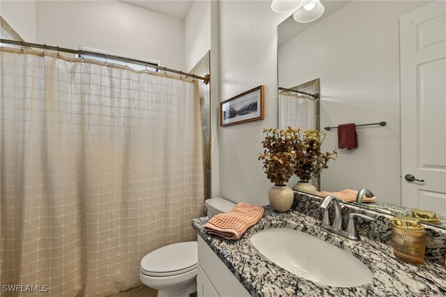 full bathroom featuring curtained shower, vanity, and toilet