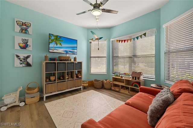 living area with wood finished floors and ceiling fan