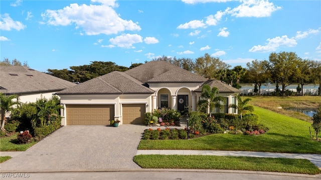 view of front of home with stucco siding, an attached garage, decorative driveway, a front lawn, and a shingled roof