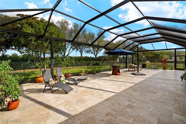 view of patio / terrace featuring glass enclosure and fence