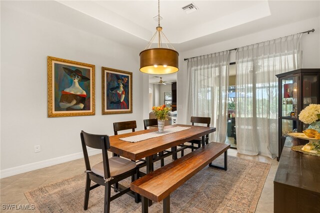 dining room with a wealth of natural light, a tray ceiling, and visible vents