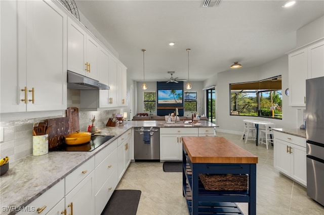 kitchen featuring backsplash, white cabinetry, butcher block counters, under cabinet range hood, and stainless steel appliances