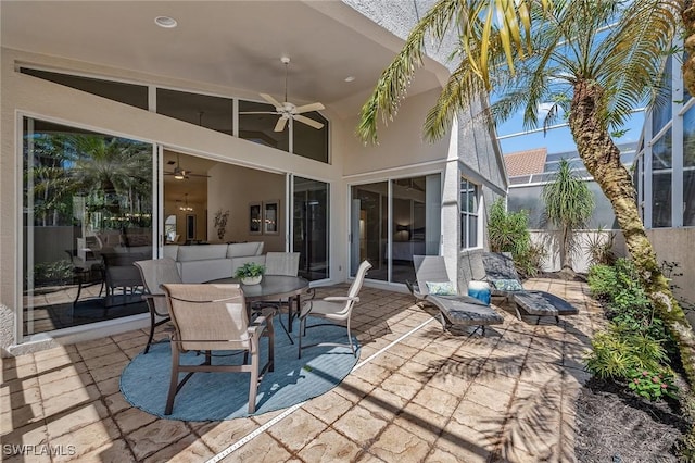 view of patio with outdoor dining area, a ceiling fan, and fence