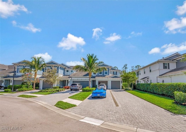 view of property featuring a garage, a residential view, and driveway