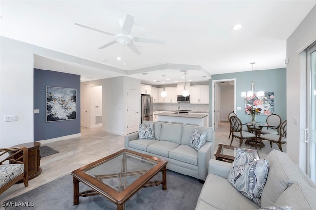 living room with baseboards, recessed lighting, light wood-style flooring, visible vents, and ceiling fan with notable chandelier