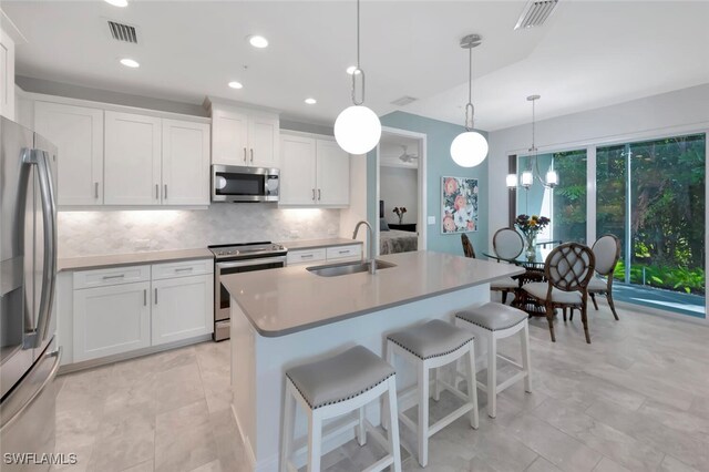 kitchen with stainless steel appliances, visible vents, a sink, and decorative backsplash