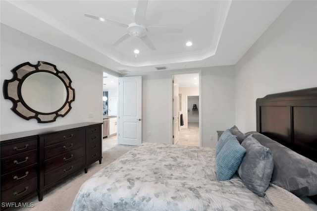 bedroom featuring light carpet, recessed lighting, ensuite bath, visible vents, and a raised ceiling