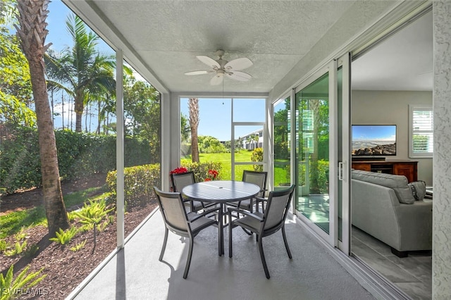 sunroom featuring a ceiling fan and outdoor dining area