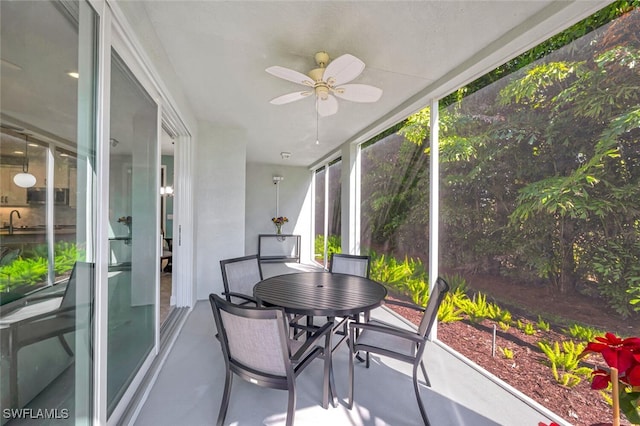 sunroom featuring ceiling fan, finished concrete flooring, and a healthy amount of sunlight