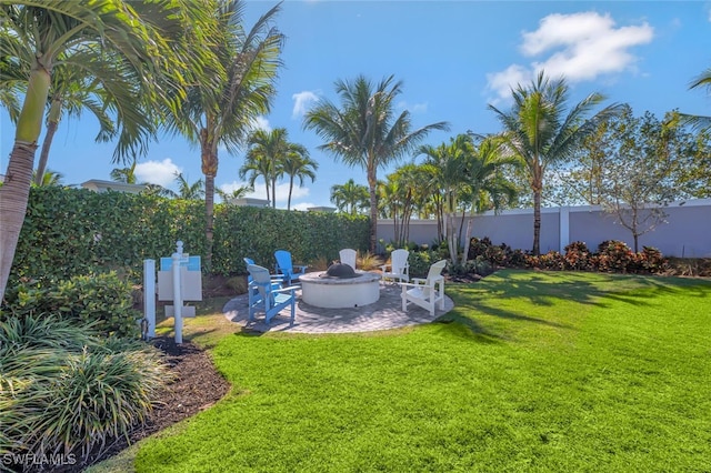 view of yard featuring a patio area, a fenced backyard, and a fire pit