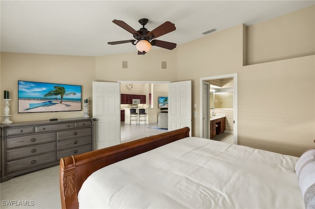 bedroom featuring visible vents, light carpet, connected bathroom, lofted ceiling, and ceiling fan