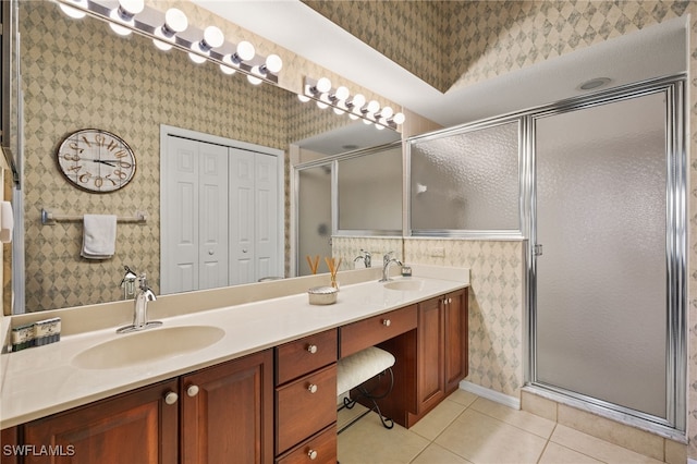 full bathroom featuring wallpapered walls, double vanity, a stall shower, tile patterned floors, and a sink