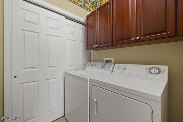 laundry area featuring washing machine and clothes dryer and cabinet space