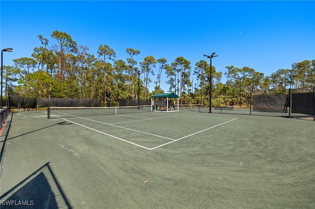 view of tennis court featuring fence