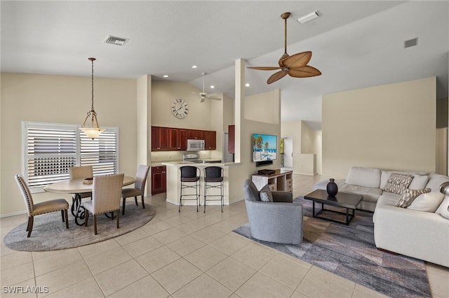 living area featuring visible vents, light tile patterned flooring, and a ceiling fan