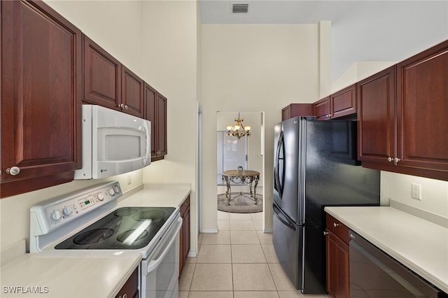 kitchen with visible vents, dark brown cabinets, light countertops, light tile patterned floors, and white appliances