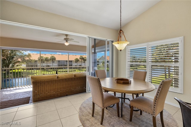 dining room featuring light tile patterned floors, baseboards, lofted ceiling, and ceiling fan