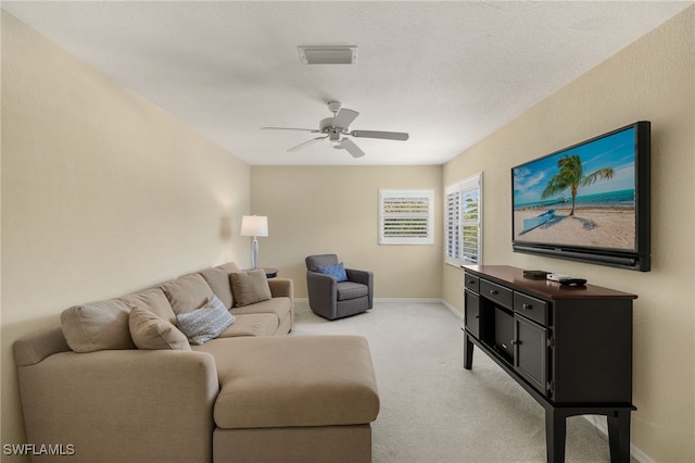 living room with visible vents, light colored carpet, baseboards, and ceiling fan