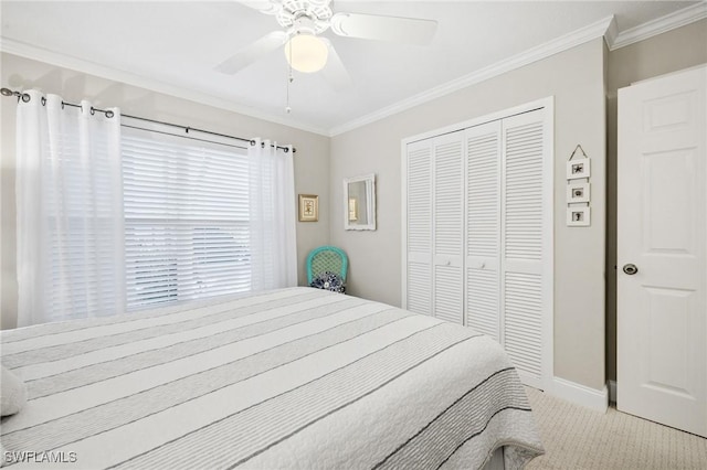 bedroom featuring baseboards, ceiling fan, carpet, crown molding, and a closet