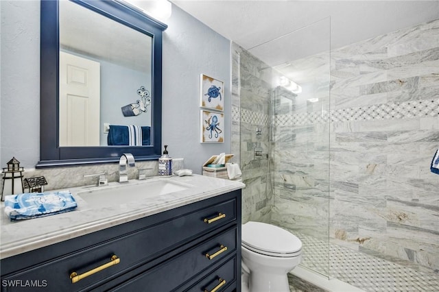 full bathroom featuring a shower stall, toilet, and vanity