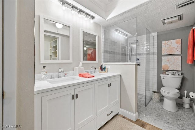 bathroom with visible vents, a sink, a textured ceiling, and walk in shower