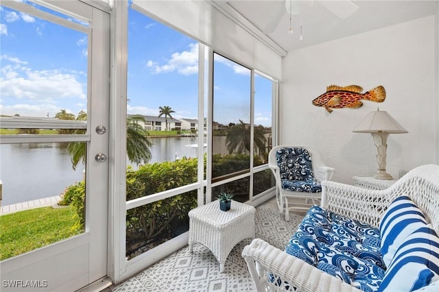 sunroom featuring a water view and ceiling fan