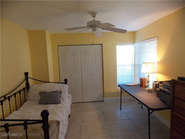 bedroom featuring a closet, tile patterned flooring, a ceiling fan, and baseboards