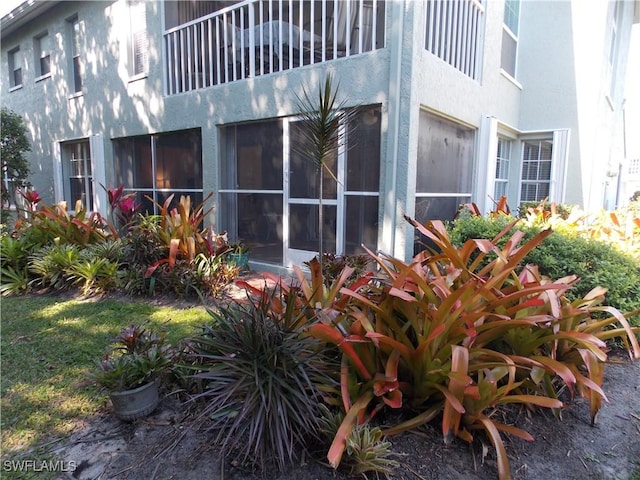 view of home's exterior with a balcony and stucco siding