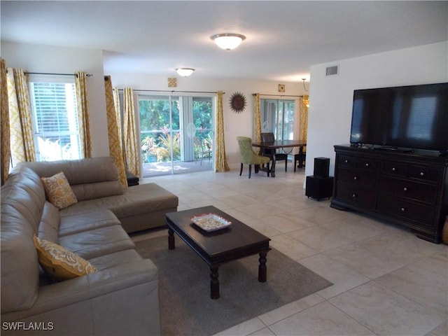 living area featuring visible vents and light tile patterned flooring