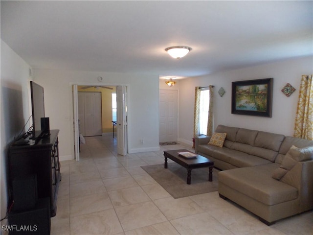 living area featuring baseboards and light tile patterned floors