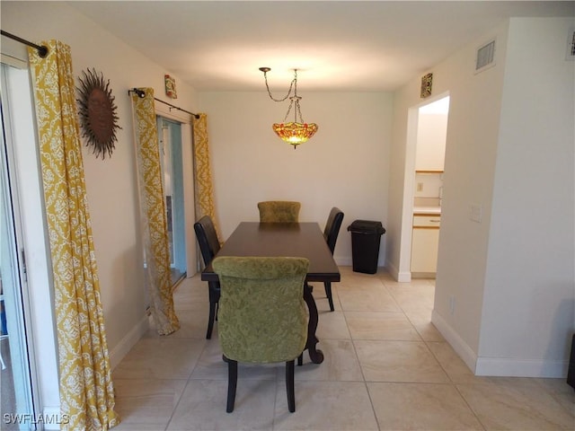 dining room featuring light tile patterned floors, visible vents, and baseboards