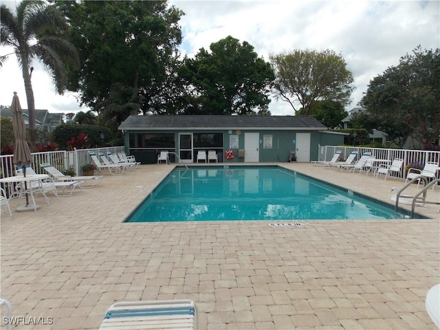 pool with a patio area and fence