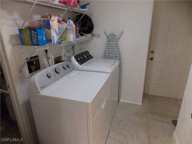 laundry room with laundry area, independent washer and dryer, and light tile patterned floors