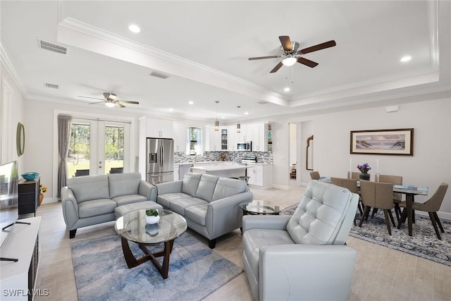 living room featuring visible vents, a raised ceiling, and french doors