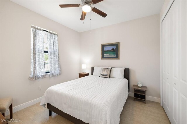 bedroom featuring light wood-type flooring, a ceiling fan, baseboards, and a closet