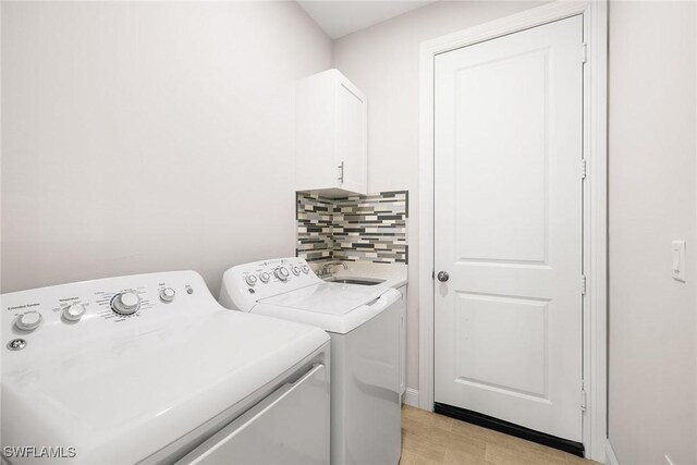 laundry room with cabinet space, a sink, and separate washer and dryer