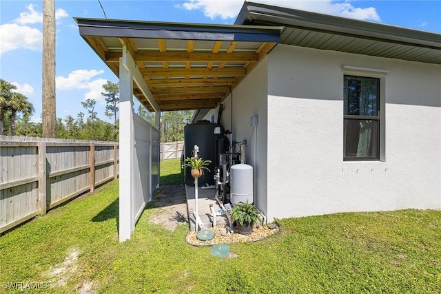 view of home's exterior featuring a lawn, fence, and stucco siding