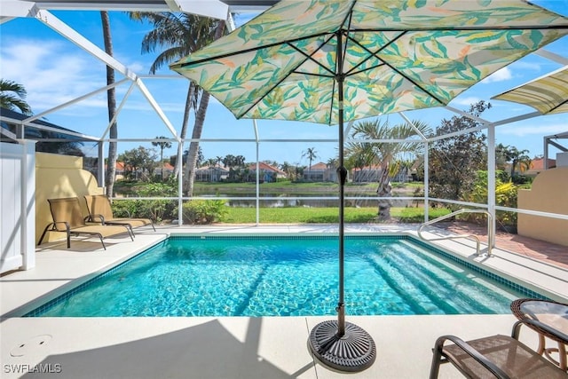 pool featuring a patio, a water view, and glass enclosure