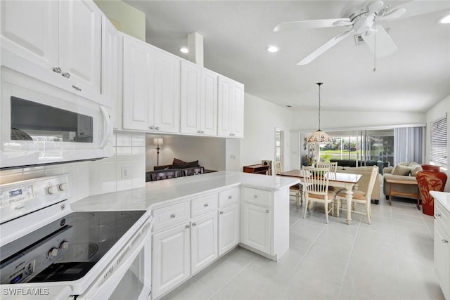 kitchen with a peninsula, white appliances, tasteful backsplash, and white cabinets