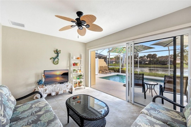 tiled living area featuring ceiling fan, a sunroom, visible vents, and baseboards