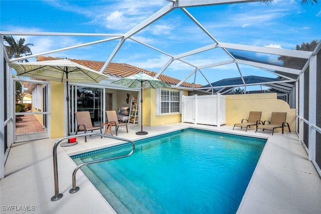 pool featuring glass enclosure and a patio