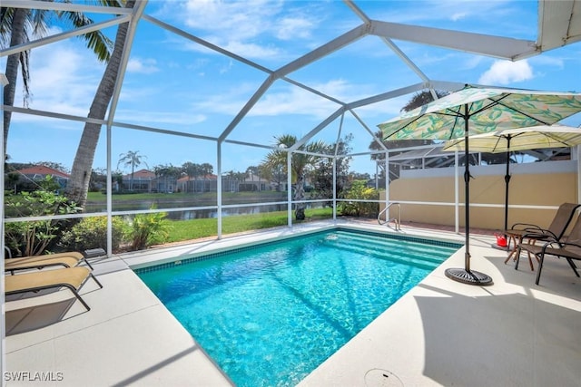 outdoor pool featuring glass enclosure, a water view, and a patio