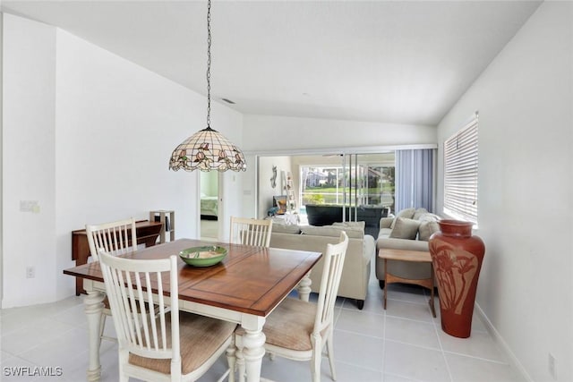 dining area featuring vaulted ceiling and light tile patterned floors